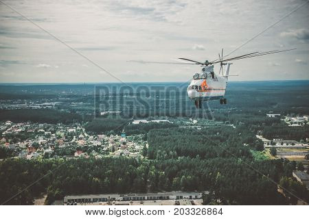 A Large Helicopter Is Flying In The Blue Sky.