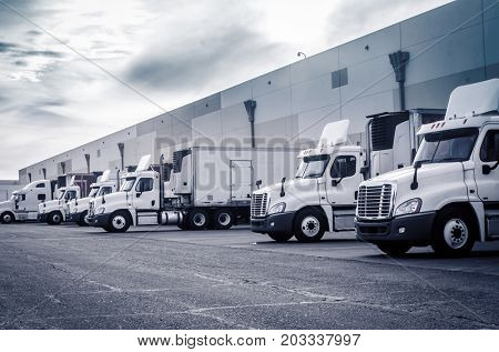 Delivering or Supply concept image.  Trucks loading at facility.