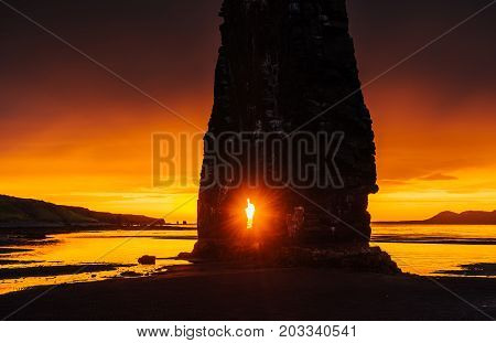 Is a spectacular rock in the sea on the Northern coast of Iceland. Legends say it is a petrified troll. On this photo Hvitserkur reflects in the sea water after the midnight sunset