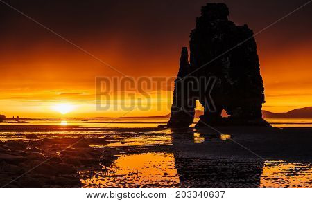 Is a spectacular rock in the sea on the Northern coast of Iceland. Legends say it is a petrified troll. On this photo Hvitserkur reflects in the sea water after the midnight sunset