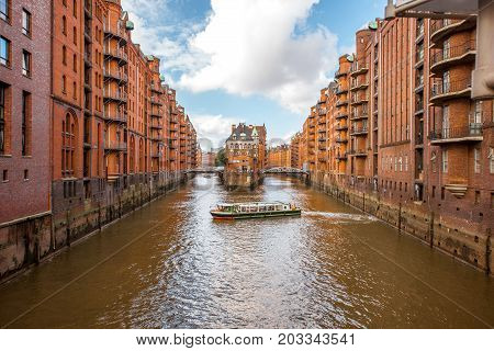 Beautiful view on the water channel with old red warehouses in Hafen district of Hamburg city, Germany
