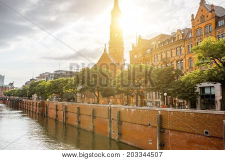 Beautiful cityscape view on the water channel with old church in Hamburg city during the sunset in Germany