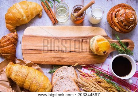 Fresh tasty bread with coffee and honey bee with milk on the table.