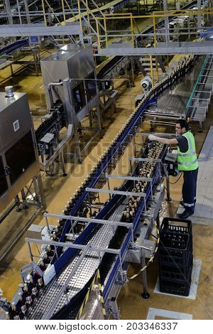 ST. PETERSBURG, RUSSIA - AUGUST 11, 2016: Worker at beer conveyor in the Heineken brewery. It was the first Heineken brewery in Russia, and now it can produce over 5 millions HL of beer per year