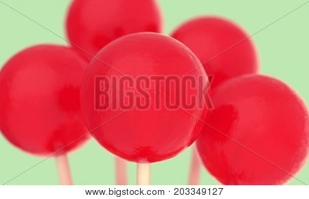 Retro styled red balls of lollipops on a stick. Macro shot with shallow DOF. Horizontal wide pop art style poster with close up round candies