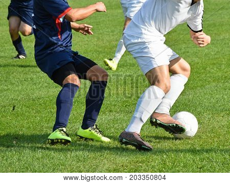 Soccer players in action outdoors in summer