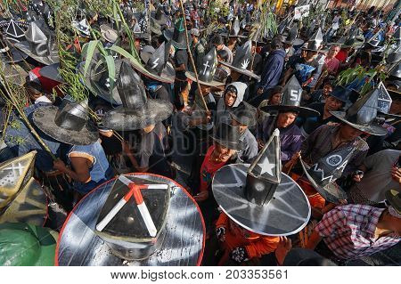 June 29 2017 Cotacachi Ecuador: crowd of kichwa indigenous men walking and dancing in the town plaza at Inti Raymi seen from above
