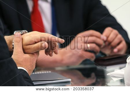 Two businessmen talking at table - discussion on conversations - close upview