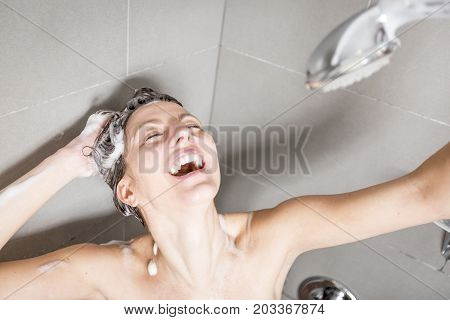 A beautiful Woman in shower washing hair with shampoo