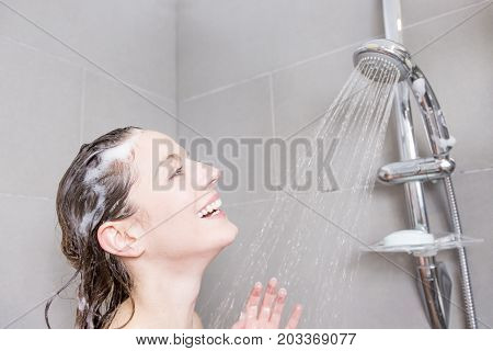 A beautiful Woman in shower washing hair with shampoo