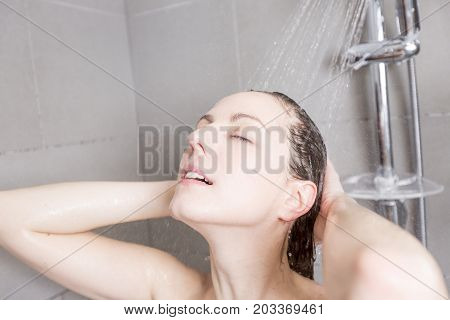 A beautiful Woman in shower washing hair with shampoo