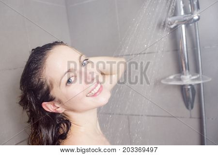 A beautiful Woman in shower washing hair with shampoo