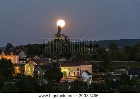The statue of Pope Urbanus 2 in the Champagne village of Chatillon-sur-Marne in the Champagne district in France rising of the full moon.
