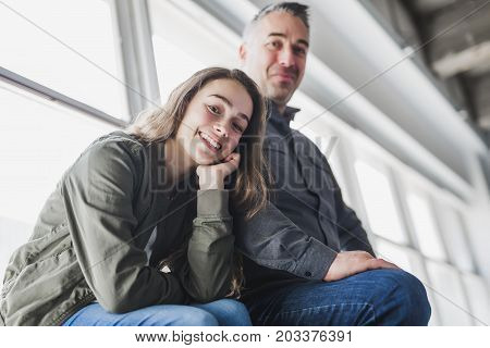 A nice and cool Teenager girl sitting on window with father