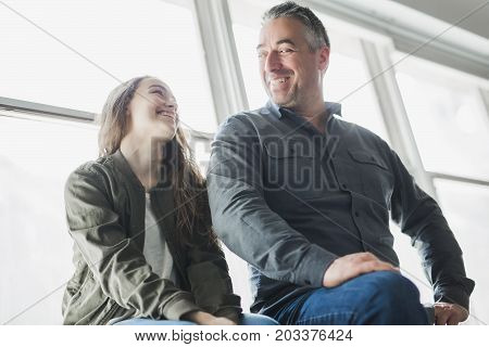 A nice and cool Teenager girl sitting on window with father
