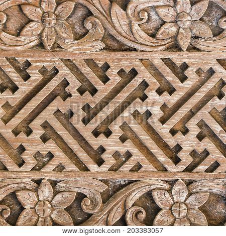 Detail of a beautiful carved wooden door of a temple in Ubud Bali Indonesia . Close up