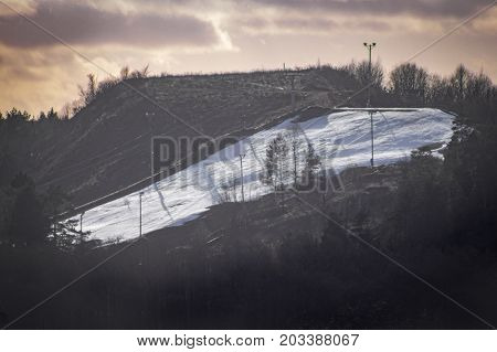 Snowy skii hill far away with an interesting sky in the background