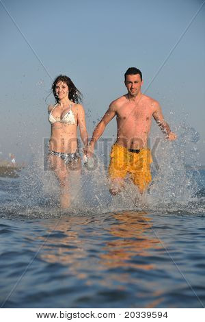 Szczęśliwa młoda para miłej zabawy i romantyczne chwile na plaży w sezonie letnim i reprezentujących happynes