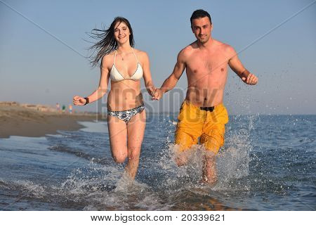 Szczęśliwa młoda para miłej zabawy i romantyczne chwile na plaży w sezonie letnim i reprezentujących happynes