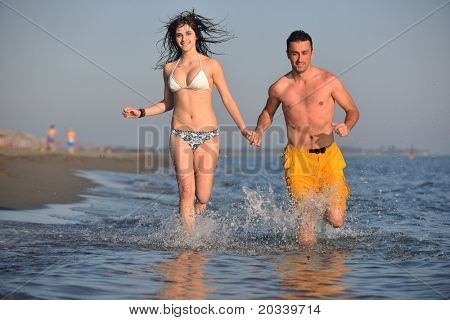 Szczęśliwa młoda para miłej zabawy i romantyczne chwile na plaży w sezonie letnim i reprezentujących happynes