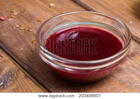 Sauce in a glass bowl on a background of a board