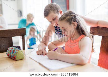 A cute teen girl doing homework at home