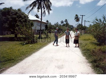 NUKU'ALOFA, TONGATAPU / TONGA - CIRCA 1990: Three young men pose for a photograph in an alley in Tonga's capital city.