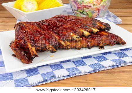 Barbecued pork ribs meal with sweetcorn and fresh salad