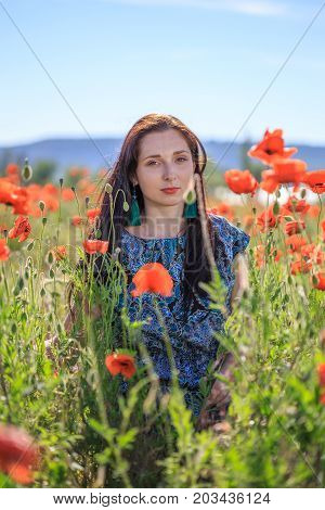Portrait Of Pensive Woman Among Poppy Flowers