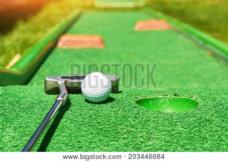 Golf ball and Golf Club on Artificial Grass.