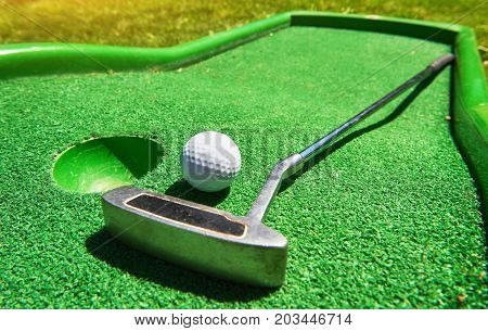 Golf ball and Golf Club on Artificial Grass.