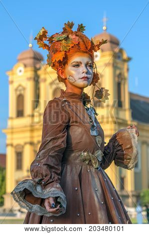 TIMISOARA ROMANIA - SEPTEMBER 8 2017: Living statue of a woman dressed with autumn elements and present on the street inside the CheckART Carnival organized by the City Hall Timisoara. Union Square.