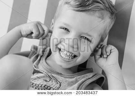 happy little boy covering his ears and laughing (Black and white)