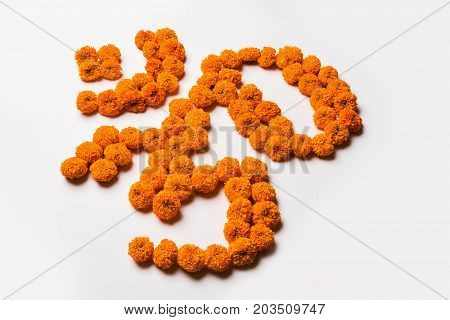 Stock photo of word Aum or om made using marigold flower arrangement