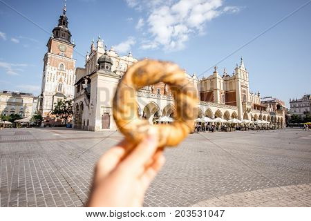 Holding prezel, traditional polish snack on the Market square in Krakow