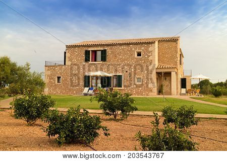 CAMPOS MALLORCA SPAIN - August 30 2017: Old Mediterranean finca buildings built in traditional island style and garden with orange trees in front. Balearic islands. Summer 2017.