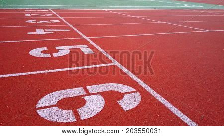 Start numbering Jogging sports rubberized red track stadium on the street selective focus