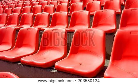 Red plastic seats grandstand stadium in the fresh air day and light