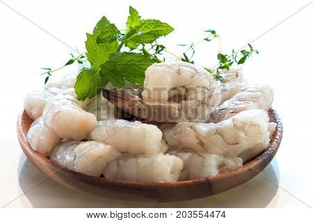Raw fresh shrimps in a wooden plate.