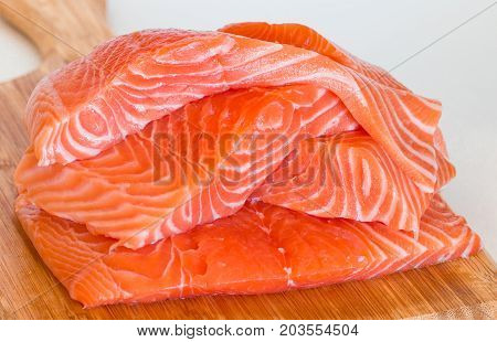 fresh raw salmon on wooden cutting board