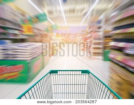 Supermarket store abstract blur background with shopping cart Supermarket aisle with empty shopping cart