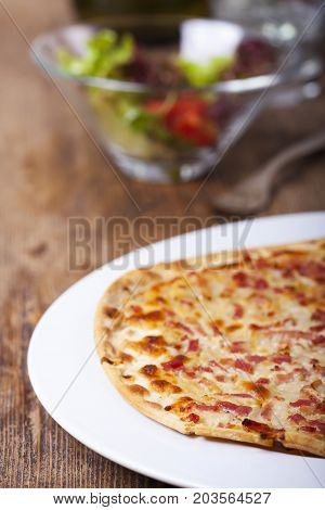 french flammkueche with salad and fork on wood