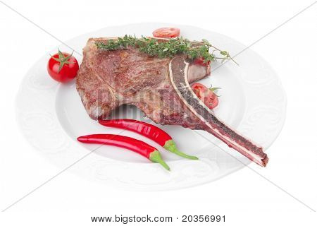cibo di carne: arrosto nervatura sul piatto bianco con ramoscello di timo, pepe e pomodoro isolato su bianco energetic