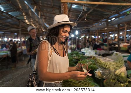 Young Woman Paying Money For Fresh Vegetables On Market Girl Shopping On Trational Street Bazaar