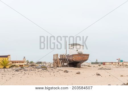 WLOTZKASBAKEN NAMIBIA - JUNE 29 2017: A wooden fishing boat used as holiday home in Wlotzkasbaken a small holiday village in the Namib Desert on the Skeleton Coast of Namibia