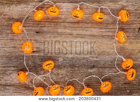 orange halloween carved glowing pumpkin on wooden table with copy space
