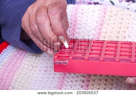 Senior Citizen taking Pill.
A senior citizen, in a wheelchair, being given her medication by a carer.