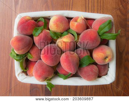 Ripe Peaches In Basket On Wooden Background.
