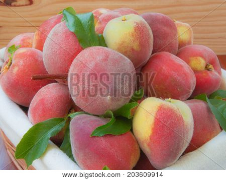 Ripe Peaches In Basket On Wooden Background.