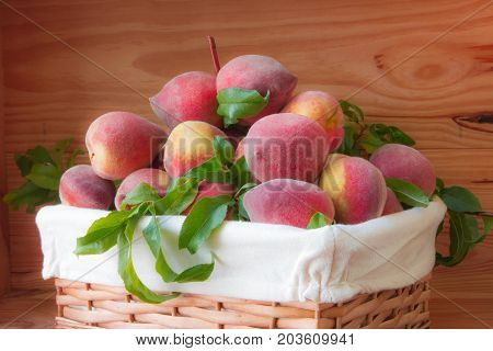 Ripe Peaches In Basket On Wooden Background.